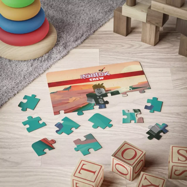 The durable metal collector's tin for the Roblox puzzle, shown next to the finished product.