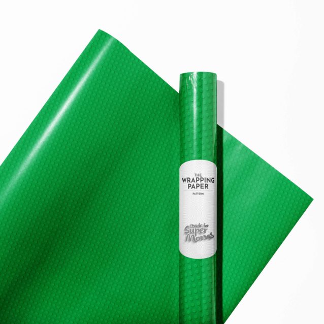 A brightly wrapped gift using Lego wrapping paper with a bow.