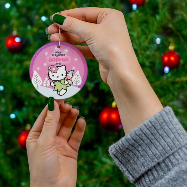 Angel Kitty in a green fairy dress over a pink winter sky - personalized Hello Kitty Christmas ornament with name and year