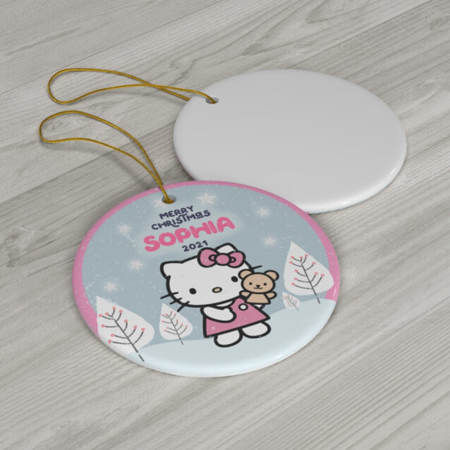 Hello Kitty in a red dress holding her teddy in a blue winter village - custom name Christmas ornament