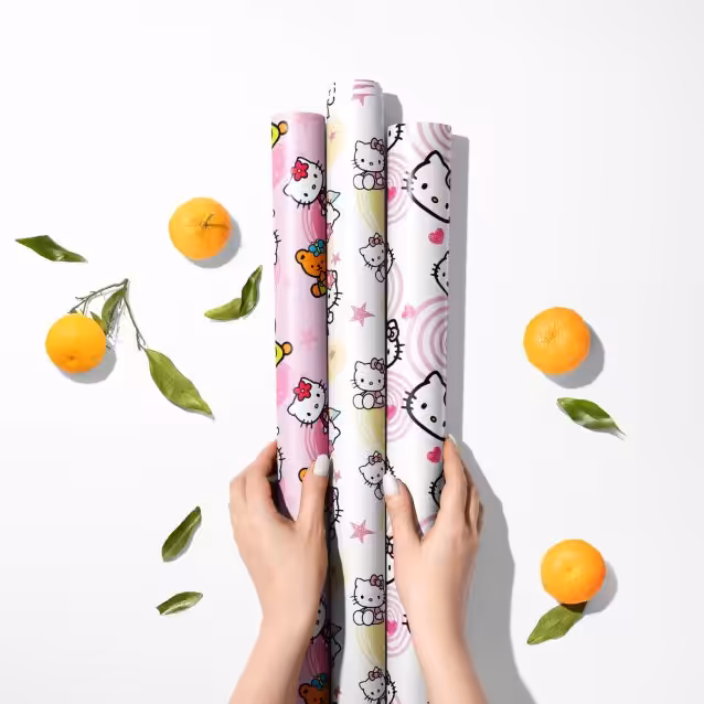 Close-up of glossy Hello Kitty gift wrap with multiple cute kitty characters.