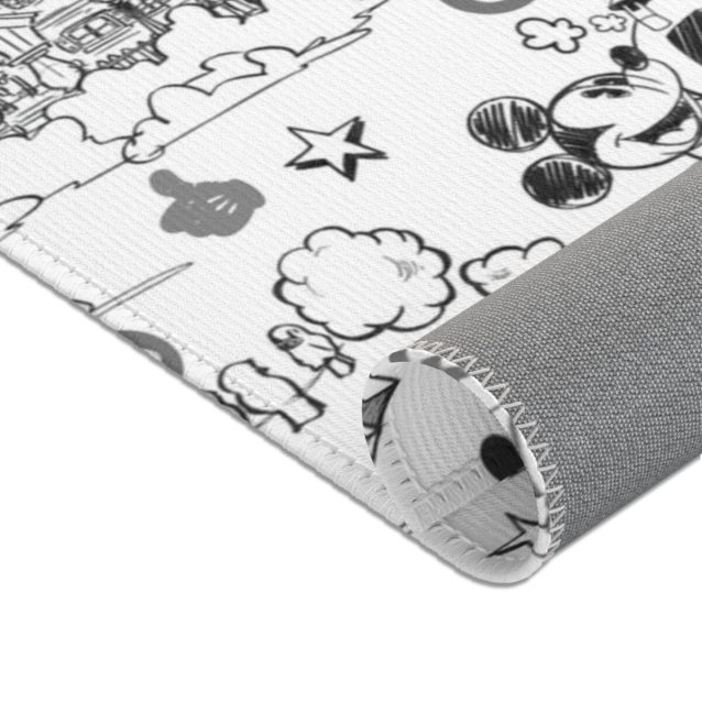 The white stitched edge of the black and white Mickey Mouse rug.
