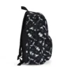 Detailed side shot of the dark alternative skulls and ravens fabric pattern on our custom personalized Wednesday Addams school bag.