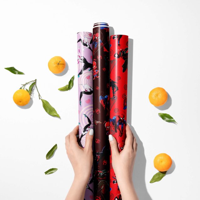 Hands wrapping a large box with the extra-long 30x180 inch roll of Marvel superhero gift wrap.