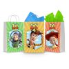 Three printable Toy Story 4 goodie bag fronts on paper party bags — Buzz Lightyear, Woody and Jessie, each a framed portrait under the Toy Story 4 logo on a striped starburst background.