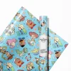 Festive Toy Story Christmas wrapping paper. Woody and Buzz Lightyear are pictured wearing Santa hats amidst a flurry of snowflakes and holiday ornaments, creating a magical look for under-the-tree presents.