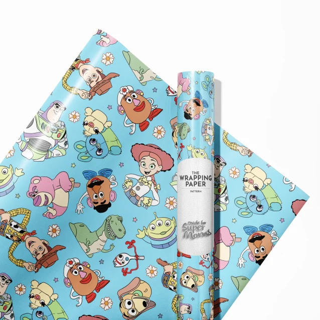 Festive Toy Story Christmas wrapping paper. Woody and Buzz Lightyear are pictured wearing Santa hats amidst a flurry of snowflakes and holiday ornaments, creating a magical look for under-the-tree presents.