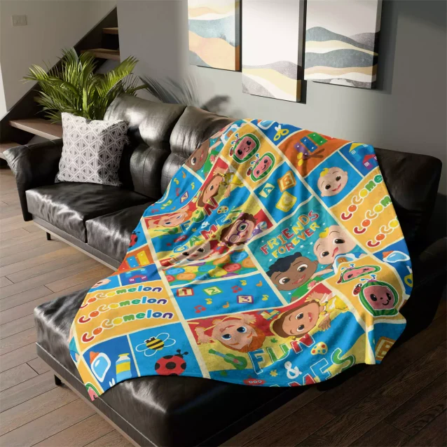 Child holding a Cocomelon fleece blanket with their name printed on it.