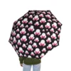 The Minnie Mouse umbrella held against a grey, rainy sky.