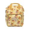 Soft yellow Winnie the Pooh diaper bag backpack covered in classic Pooh honey-pot art, personalized with the baby's name on the front pocket.