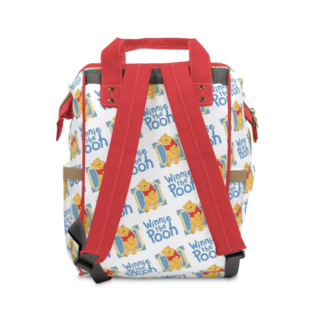 Pack for your little one in a vibrant red diaper backpack adorned with Winnie the Pooh.