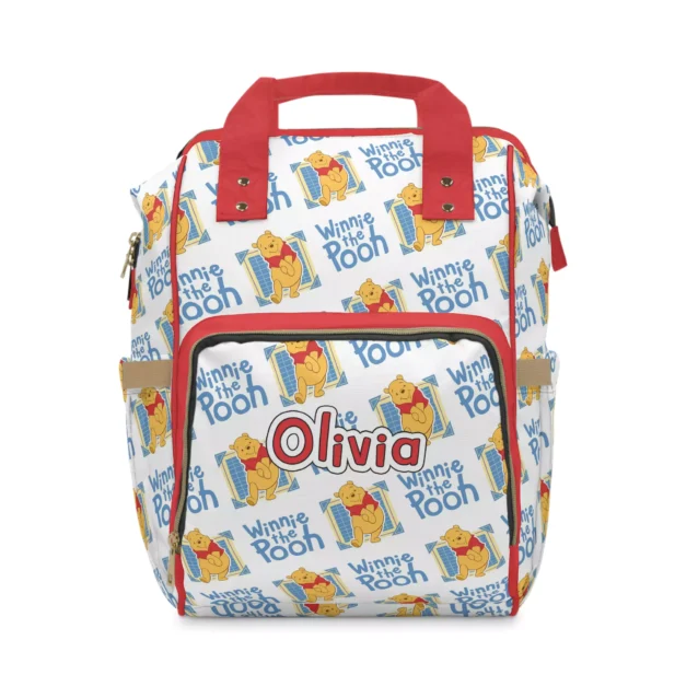 White Winnie the Pooh nappy bag with red handles and an all-over vintage Pooh logo print.