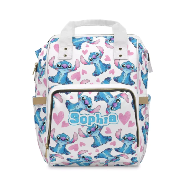 White Stitch diaper bag backpack with blue Stitch poses and pink hearts, the baby's name printed on the front pocket.