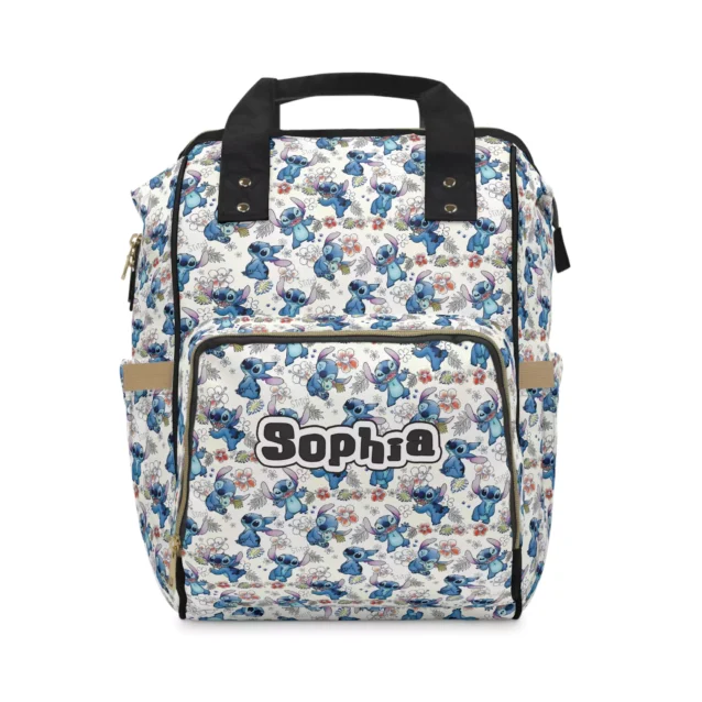 Cream Stitch doodle diaper bag with dense blue Stitch art and black handles.