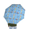 The Bluey umbrella beside a lunch bag and backpack, packed for the day.