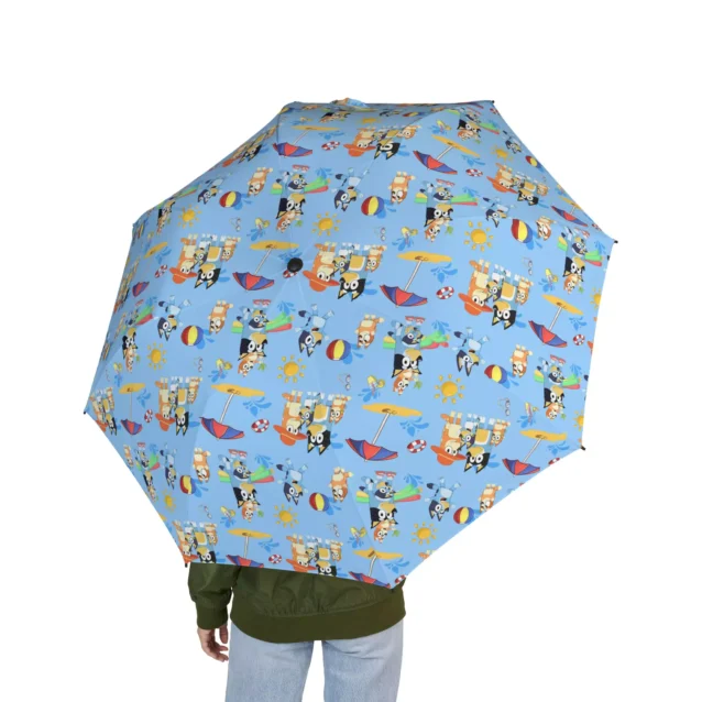 A child carrying the Bluey umbrella on the way to school.