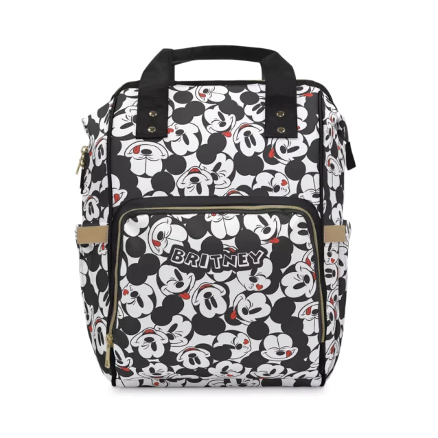 Black and white tossed Mickey faces diaper bag backpack personalized with the baby's name on the front pocket.