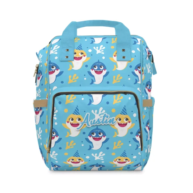 Bright blue Baby Shark diaper bag with party-hat sharks, coral and seaweed, personalized with the baby's name.