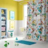 Child happily pointing at their new personalized Paw Patrol shower curtain in the bathroom.