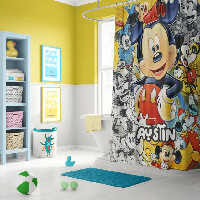A child smiling at their personalized Mickey Mouse shower curtain with their name.