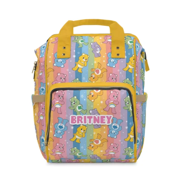 Yellow rainbow-stripe Care Bears diaper bag with the Care Bears and rainbow tummies.