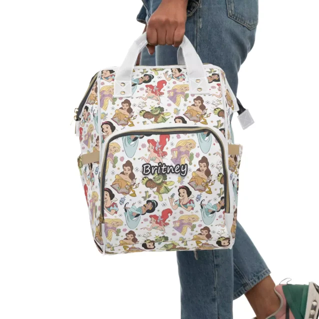 A dad comfortably wearing the Disney Princess diaper bag with a smiling baby in a carrier.