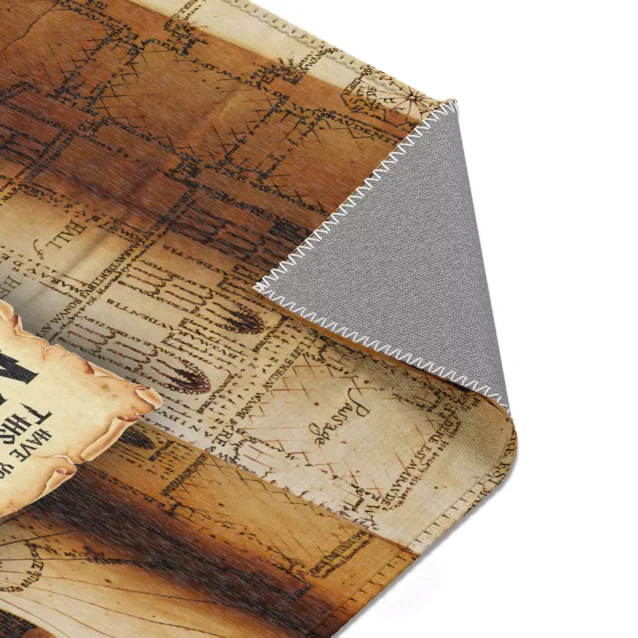 The Marauder's Map Rug displayed in a cozy reading nook, with a stack of Harry Potter books and a wand resting on it.