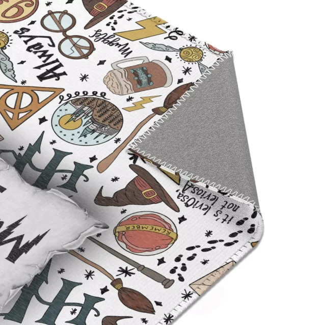 A soft and colorful Harry Potter themed rug laid out in a child's bedroom, featuring iconic symbols from the movies.