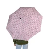 A person holding the Hello Kitty umbrella in the rain, showcasing its waterproof fabric.