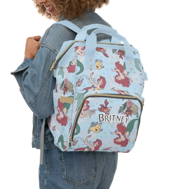 A dad carrying the stylish and unisex Little Mermaid diaper backpack.