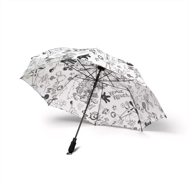 The compact, folded Mickey Mouse umbrella next to a handbag for scale.