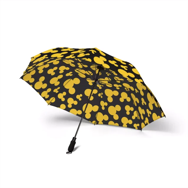 A lifestyle image of the Mickey Mouse umbrella leaning against a park bench.