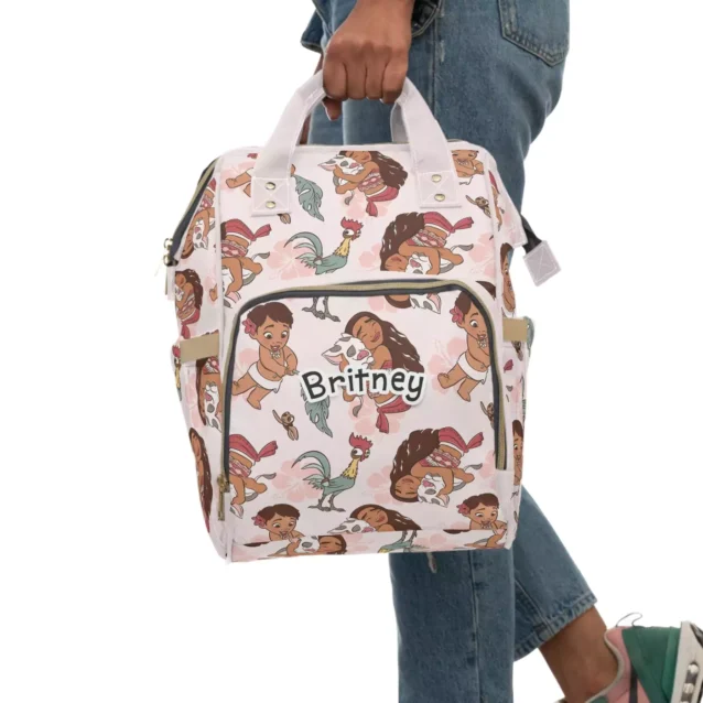 Moana diaper bag held by the top handles, personalized with the baby's name.