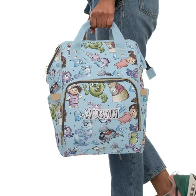 A mom carrying the Monsters Inc diaper bag on her back.