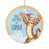 Flat lay of the personalized Pooh Bear ornament next to a gift box, showing the gold hanging string.
