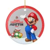 Nintendo Super Mario ornament hanging on a festive Christmas tree next to twinkling lights.