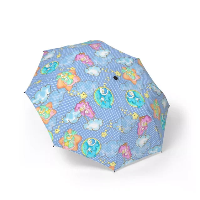 Matching pink wrist strap on the ergonomic handle of the compact Care Bears umbrella.