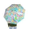 Side profile of a child safely shielded from the rain by a Care Bears bubble umbrella.