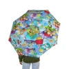 Red Snoopy Flying Ace umbrella fully open against a rainy city background.
