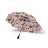 Person holding a black Stranger Things umbrella walking through a rainy city street.
