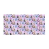 Personalized Kpop beach towel laid flat on white beach sand.