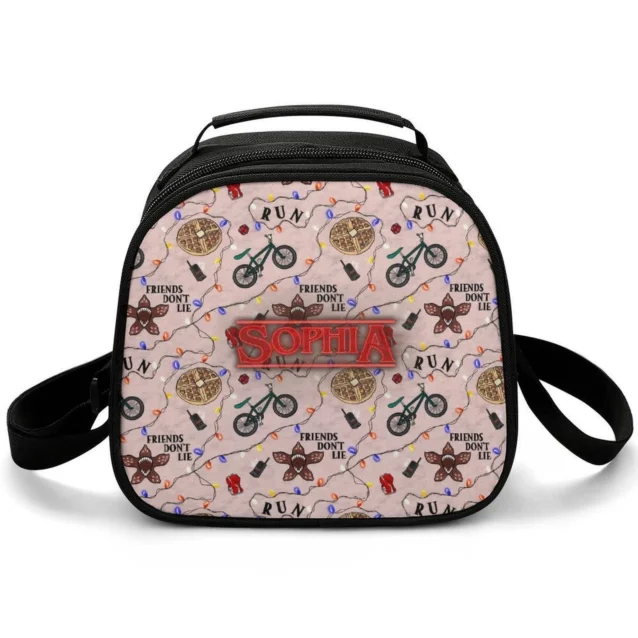 Cream Stranger Things lunch bag repeating "Friends Don't Lie" with waffles, fairy lights and bikes, personalized with a custom name.