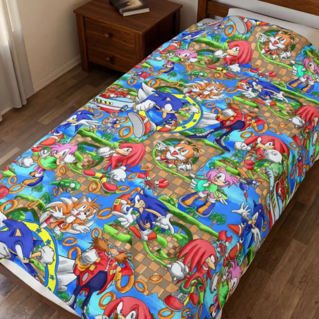 Sonic Blanket in the Sonic Character Collage design with Sonic, Tails, Knuckles and Amy, shown on a kids bed