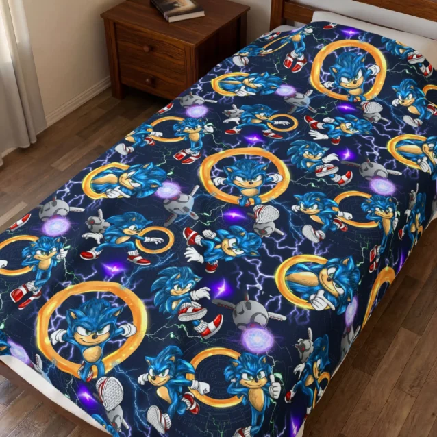 Sonic Blanket in the Gold Rings All-Over design with Sonic and gold rings on navy, shown on a kids bed