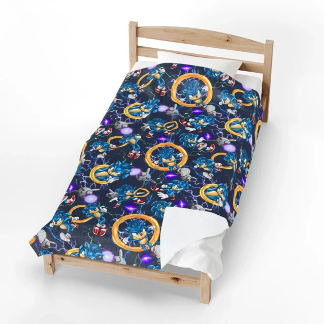 Sonic Blanket in the Gold Rings All-Over design with Sonic and gold rings on navy, shown made up in a bedroom