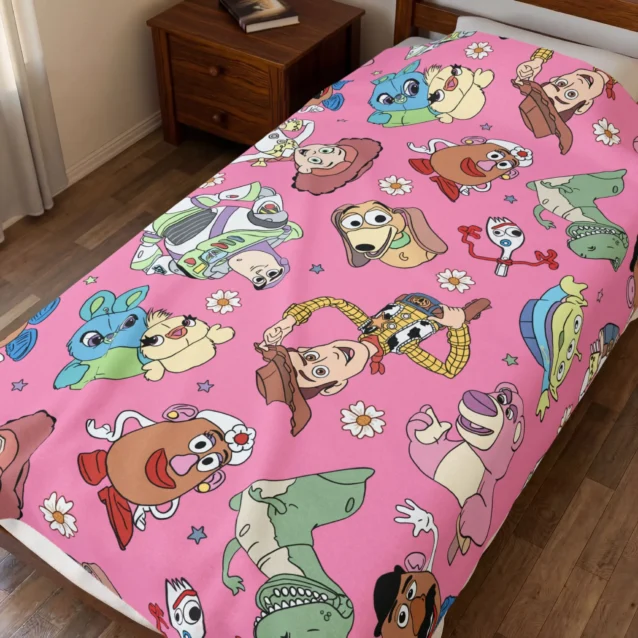 Toy Story throw blanket in the Pink Character Print design, styled in a bedroom.