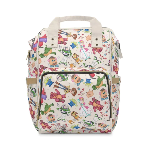 Cream Toy Story diaper bag with a doodle toss of Bo Peep, Buzz, Forky, Slinky Dog, the aliens and the Potato Heads.